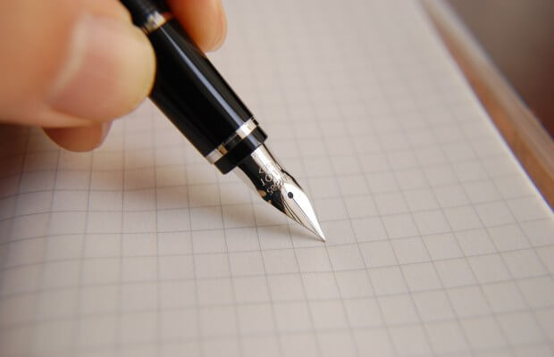 Pisanie piórem na arkuszu papieru