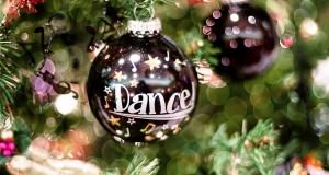 Świąteczna bombka z napisem "Dance" wisząca na choince