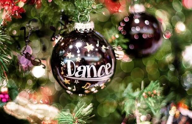 Świąteczna bombka z napisem "Dance" wisząca na choince