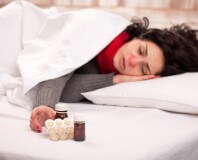 Kobieta chora na grypę leży w łóżku
